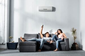 couple-on-sofa-changing-temperature-on-mini-split-with-remote