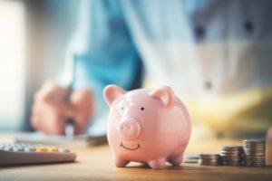 piggy-bank-with-man-using-computer-behind-it