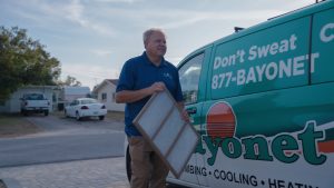 bayonet-tech-holding-air-filter-in-front-of-company-van